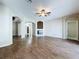 Open living room with a ceiling fan, fireplace, wood floors, and neutral paint at 1919 Oswego Dr, Holiday, FL 34691