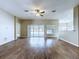 Spacious living room with wood floors, ceiling fan, and sliding glass doors to the backyard at 1919 Oswego Dr, Holiday, FL 34691