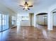 The open living area features wood floors with view into the kitchen and screened patio at 1919 Oswego Dr, Holiday, FL 34691