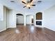 Open living room with wood floors and a fireplace that features arches at 1919 Oswego Dr, Holiday, FL 34691