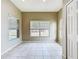 Bright, empty room with tile flooring and multiple windows offering natural light at 1919 Oswego Dr, Holiday, FL 34691