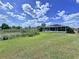 Expansive backyard with lush green grass, a scenic pond, and a charming screened-in patio at 21626 Rosewood Ct, Lutz, FL 33549