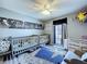 Charming Bedroom featuring dual cribs, nautical decor, and a playful, themed rug for children at 21626 Rosewood Ct, Lutz, FL 33549