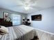 A bedroom with light gray walls, window, ceiling fan and furnishings, creating a cozy aesthetic at 21626 Rosewood Ct, Lutz, FL 33549