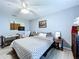 Cozy bedroom with neutral tones, features a ceiling fan, crib, and wooden furniture at 21626 Rosewood Ct, Lutz, FL 33549