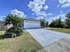 Spacious driveway leading to a well-maintained home with a two-car garage and lush landscaping at 21626 Rosewood Ct, Lutz, FL 33549