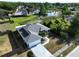 Aerial view of a home with solar panels, well-manicured front lawn and a driveway to a 2 car garage at 21626 Rosewood Ct, Lutz, FL 33549