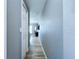 Neutral hallway with wood-look flooring, white door frames, and a view into adjoining rooms at 21626 Rosewood Ct, Lutz, FL 33549