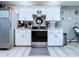 Modern kitchen features stainless steel appliances, white cabinetry, and light gray backsplash at 21626 Rosewood Ct, Lutz, FL 33549