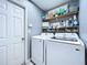 Efficient laundry room with modern washer and dryer, storage shelves, and a convenient layout at 21626 Rosewood Ct, Lutz, FL 33549