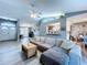 Open-concept living room with vaulted ceilings, modern gray floors, and seamless flow to the dining area at 21626 Rosewood Ct, Lutz, FL 33549