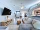 Inviting living room with vaulted ceilings, tv, and grey wood flooring at 21626 Rosewood Ct, Lutz, FL 33549