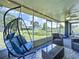 Inviting screened-in patio featuring a hanging chair and comfortable seating with views of the backyard at 21626 Rosewood Ct, Lutz, FL 33549
