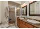 Bathroom featuring double sinks, wood cabinets, tiled shower, towel, and toilet at 2221 Soho Bay Ct, Tampa, FL 33606