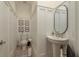 Elegant half-bathroom with wainscoting, oval mirror, pedestal sink, and neutral tones at 2221 Soho Bay Ct, Tampa, FL 33606