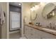 Dual sink bathroom with granite counters, tile backsplash, white cabinets, and framed mirrors at 2221 Soho Bay Ct, Tampa, FL 33606