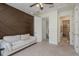 Upstairs bedroom features a brown geometric accent wall, a white sofa, and an ensuite bathroom at 2221 Soho Bay Ct, Tampa, FL 33606