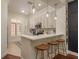 Well-lit kitchen featuring white cabinets, countertop seating and pendant lights at 2221 Soho Bay Ct, Tampa, FL 33606