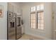 Kitchen featuring stainless steel refrigerator, white cabinets, and window with shutters at 2221 Soho Bay Ct, Tampa, FL 33606