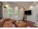 Bright living room featuring a leather sectional, ottoman, and views of the landscaped yard through white plantation shutters at 2221 Soho Bay Ct, Tampa, FL 33606