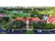 Aerial view of building with red tile roof, palm trees, parking lot, and landscaping at 2400 Feather Sound Dr # 635, Clearwater, FL 33762