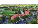 Aerial view showcases building's red tile roof nestled beside a golf course, water feature and parking at 2400 Feather Sound Dr # 635, Clearwater, FL 33762