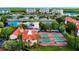 An aerial view of the property showcases the community pool, tennis courts, and nearby lakes with palm trees at 2400 Feather Sound Dr # 635, Clearwater, FL 33762