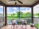 Balcony with wrought iron table and chairs overlooking the golf course and lake at 2400 Feather Sound Dr # 635, Clearwater, FL 33762