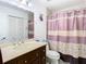 Bathroom with a vanity, toilet, and shower with pink and white curtain at 2400 Feather Sound Dr # 635, Clearwater, FL 33762