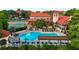 Stunning community pool area with ample seating, lush landscaping, and tennis court in the background at 2400 Feather Sound Dr # 635, Clearwater, FL 33762