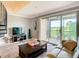 Cozy living room with gray walls, comfy sofa, and balcony access overlooking a picturesque lake at 2400 Feather Sound Dr # 635, Clearwater, FL 33762