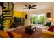 Bright living room featuring a yellow wall, spiral staircase, and a scenic balcony view at 2400 Feather Sound Dr # 635, Clearwater, FL 33762