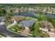 Aerial view of a beautiful home with a pool, screened lanai, landscaped yard, and lake view in a desirable community at 26701 Winged Elm Dr, Wesley Chapel, FL 33544