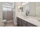 Modern bathroom with a glass-enclosed shower, a gray vanity with white countertop, and a large mirror at 26701 Winged Elm Dr, Wesley Chapel, FL 33544