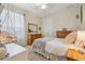 Inviting bedroom featuring a bed with a fluffy blanket, two dressers, and a macrame swing chair near the window at 26701 Winged Elm Dr, Wesley Chapel, FL 33544