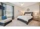 Inviting bedroom with a dark wood bed frame, accent chair, and large window with privacy blinds, creating a comfortable space at 26701 Winged Elm Dr, Wesley Chapel, FL 33544