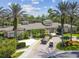 Exterior view of the clubhouse, showcasing well-maintained landscaping, palm trees, and a paver driveway at 26701 Winged Elm Dr, Wesley Chapel, FL 33544
