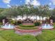 Community entrance featuring manicured landscaping, water features, and a decorative sign for 