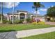 Beautiful single-story home with a well-manicured lawn, vibrant landscaping, and a symmetrical facade at 26701 Winged Elm Dr, Wesley Chapel, FL 33544