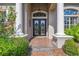 Ornate double doors framed by white columns and sidelights welcome you into this elegant residence at 26701 Winged Elm Dr, Wesley Chapel, FL 33544