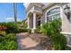 Elegant home entrance showcasing manicured landscaping, brick walkway, and decorative columns at 26701 Winged Elm Dr, Wesley Chapel, FL 33544