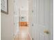 Hallway leading to the primary bath, showcasing tiled floors and neutral paint at 26701 Winged Elm Dr, Wesley Chapel, FL 33544
