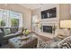 Bright living room with fireplace, large windows, a comfortable sofa, and stylish ottoman for relaxing or entertaining at 26701 Winged Elm Dr, Wesley Chapel, FL 33544