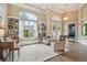 Elegant living room with a large window seat, built-in bookshelves, and coffered ceilings at 26701 Winged Elm Dr, Wesley Chapel, FL 33544
