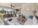 Inviting covered patio featuring comfortable seating, a ceiling fan, outdoor kitchen and dining area with lush views at 26701 Winged Elm Dr, Wesley Chapel, FL 33544