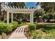 Inviting playground area featuring a white pergola, lush landscaping, and modern play equipment at 26701 Winged Elm Dr, Wesley Chapel, FL 33544