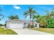 Charming single-story home featuring a lush, landscaped front yard and a two-car garage at 2675 Cherokee St, North Port, FL 34286