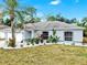 Charming single story home showcasing fresh exterior paint, tropical landscaping and an attached two car garage at 2675 Cherokee St, North Port, FL 34286
