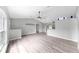 Open living room with vaulted ceilings, ceiling fan, and wood-look floors at 2675 Cherokee St, North Port, FL 34286