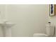 Simple powder room with a pedestal sink, toilet, and minimalist decor at 2691 Buttercup Lucine Ln, Ruskin, FL 33570